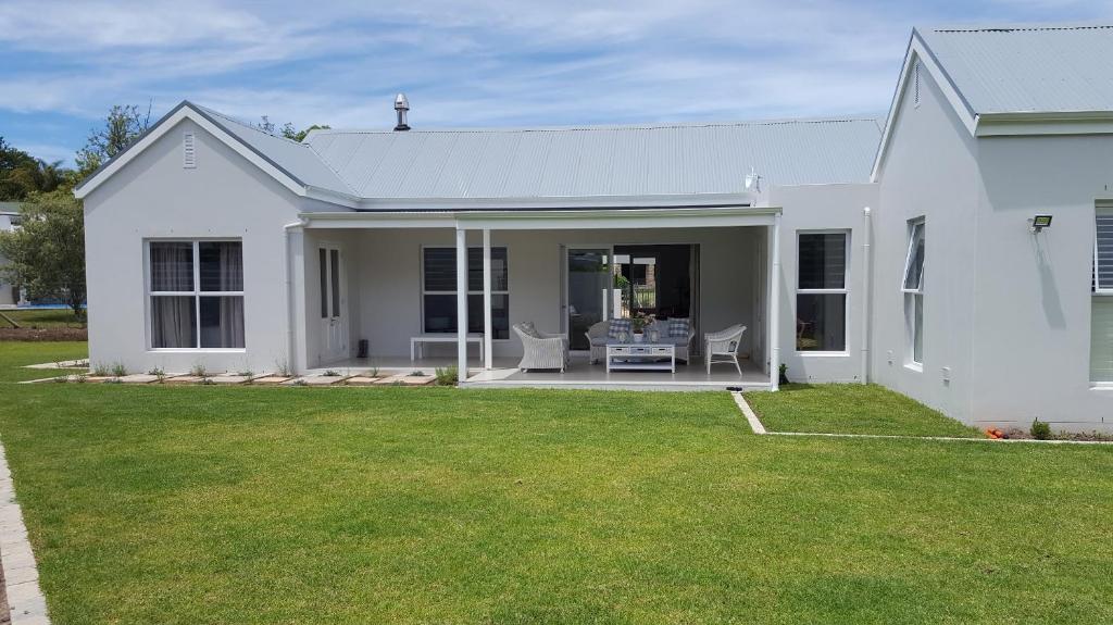 a white house with a patio and a lawn at Margie's Place in Swellendam