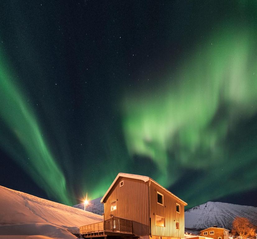 a building with the aurora in the sky at Vacation Home in Fjordgård with views of Segla and the Fjord in Fjordgård
