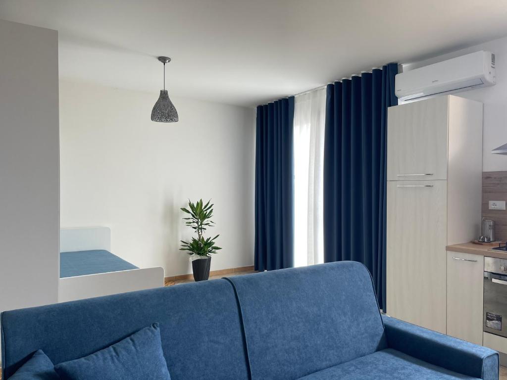 un soggiorno con divano blu e una cucina di GIOIA'S HOUSE a Custonaci