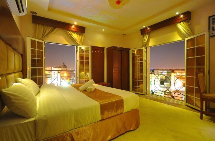 a bedroom with a bed with a view of a city at Kinda Suites in Taif