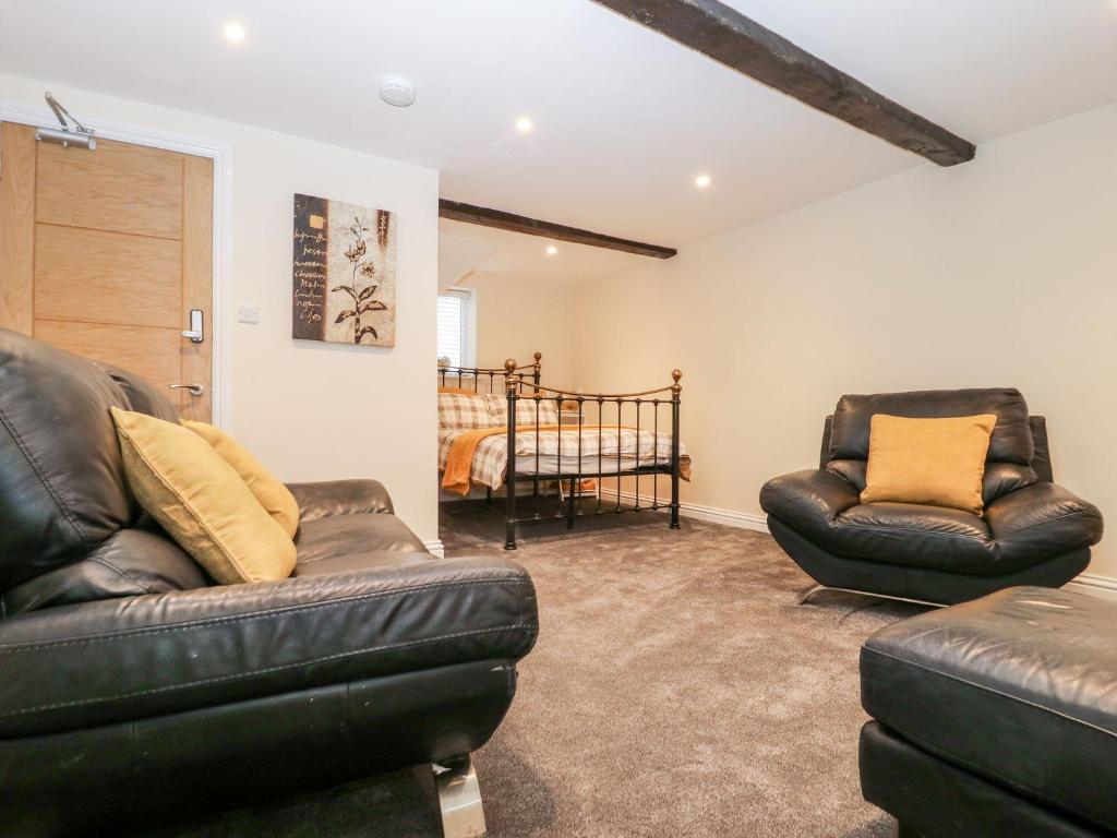 a living room with two leather chairs and a bed at Jacob’s Ally in Knaresborough