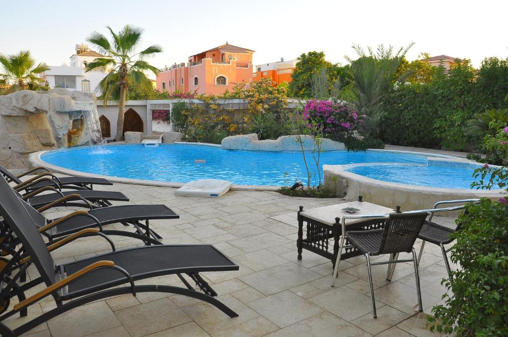 patio z krzesłami i basenem w obiekcie Villa Shahrazad Sharm El Sheikh w Szarm el-Szejk