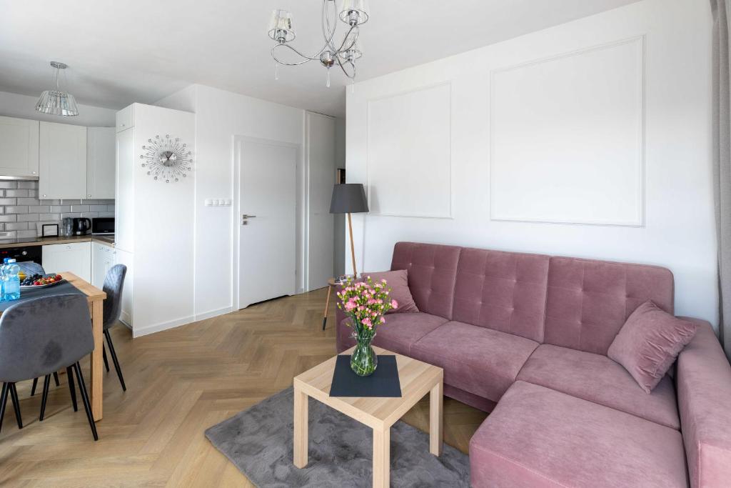 salon z fioletową kanapą i stołem w obiekcie Apartament Zagnańska Patio Vita- z garażem podziemnym w Kielcach
