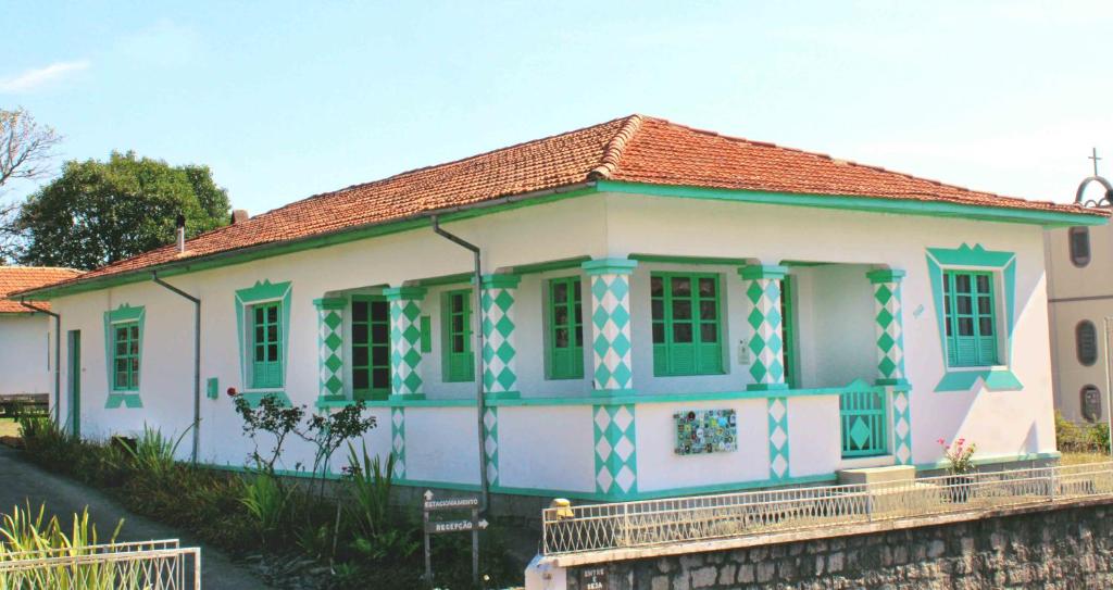 una pequeña casa con pintura verde y blanca. en Grimpa Hospedagem Urubici, en Urubici