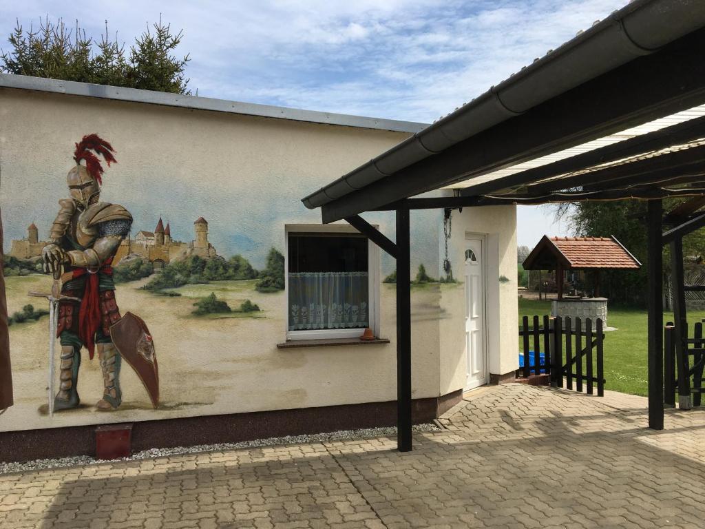 un mural en el lateral de un edificio con una pintura en Schöner Ferienbungalow umgeben von Natur und nicht weit zur Ostsee, en Neubukow