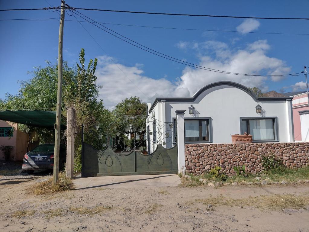 una casa blanca con una puerta verde y una pared en Casa del Portal Cafayate en Cafayate