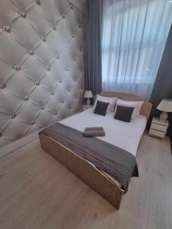 a bedroom with a large bed with a padded headboard at Willa Ela in Gdańsk