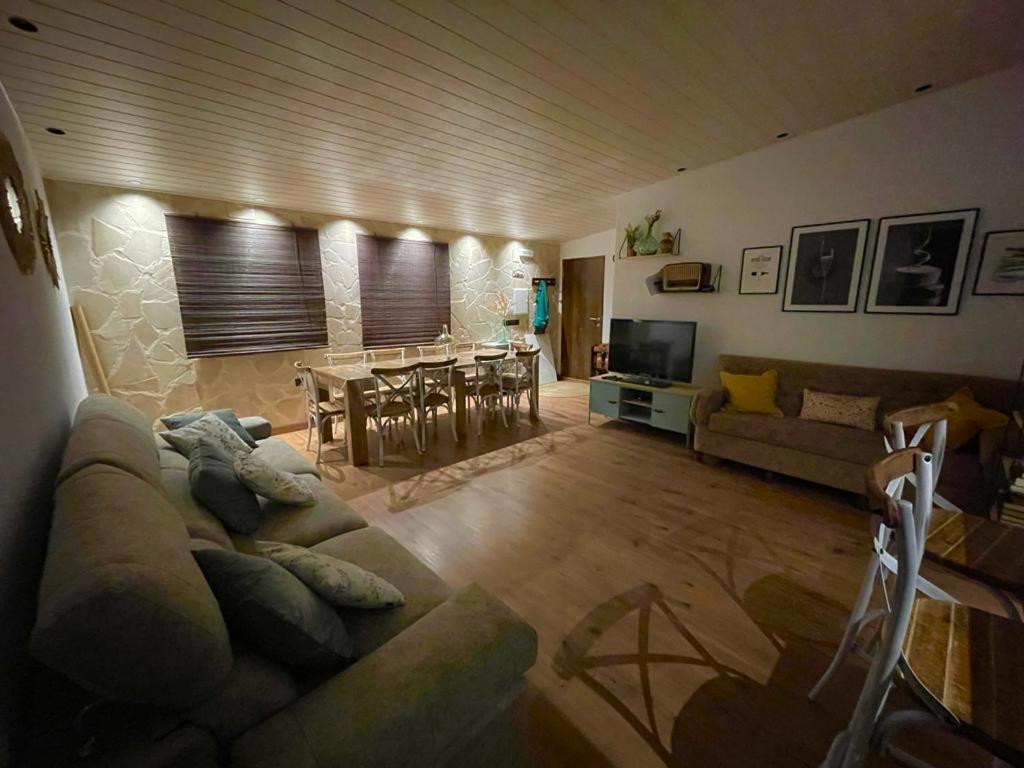 sala de estar con sofá y mesa en CASA RURAL ARENALINA, en Casas de los Pinos