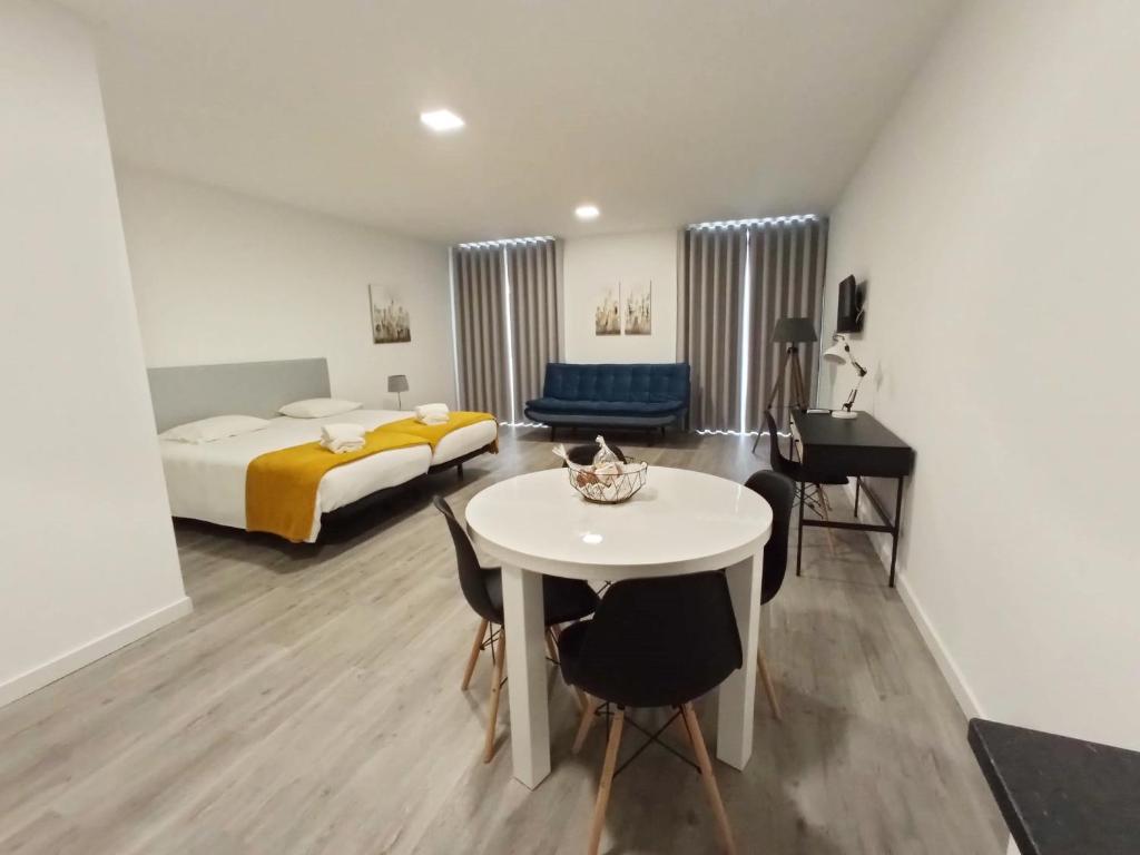 豐沙爾的住宿－Tanoeiros Studios，客房设有一张床和一张白色的桌子及椅子。