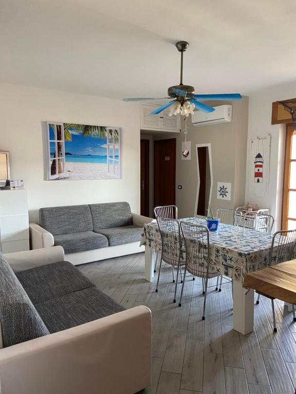 sala de estar con sofá, mesa y sillas en Casa vacanze Brezza di mare, en Tortora