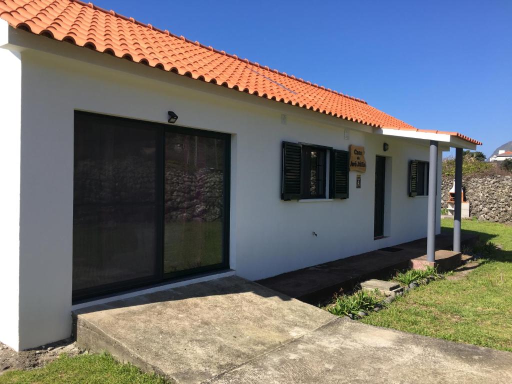 una pequeña casa blanca con techo naranja en Casa da Avó Júlia, en Faja Grande