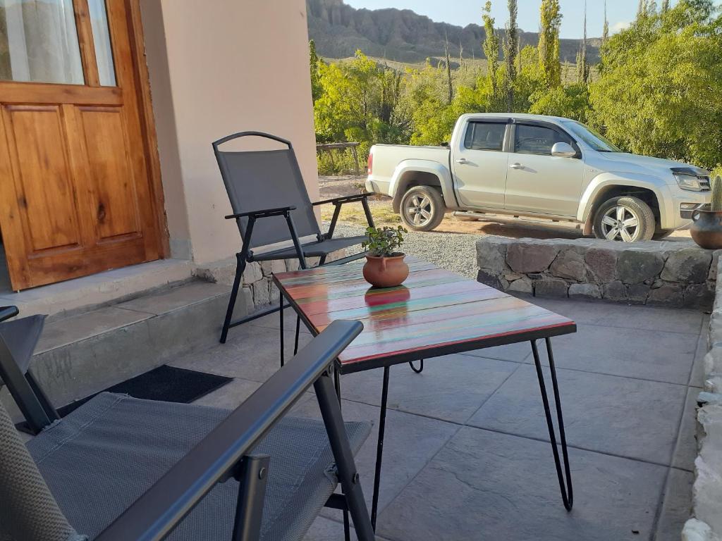 a patio with a table and chairs and a truck at Tierra Primitiva in Tilcara