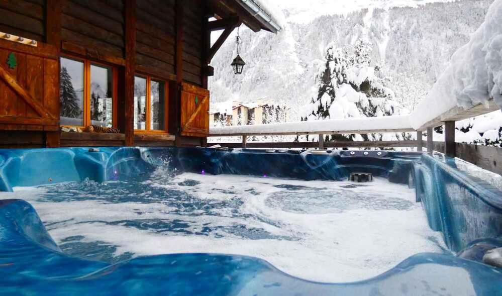 a hot tub in the snow in front of a cabin at Chalet Falcon With Hot Tub in Chamonix-Mont-Blanc