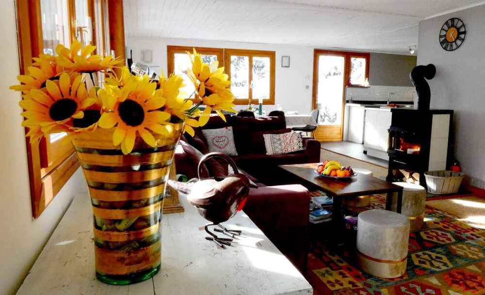 a vase with sunflowers on a table in a living room at Chalet Falcon With Hot Tub - in a great location! in Chamonix
