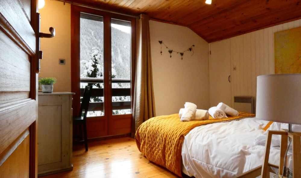 a bedroom with a bed and a large window at Chalet Falcon With Hot Tub - in a great location! in Chamonix