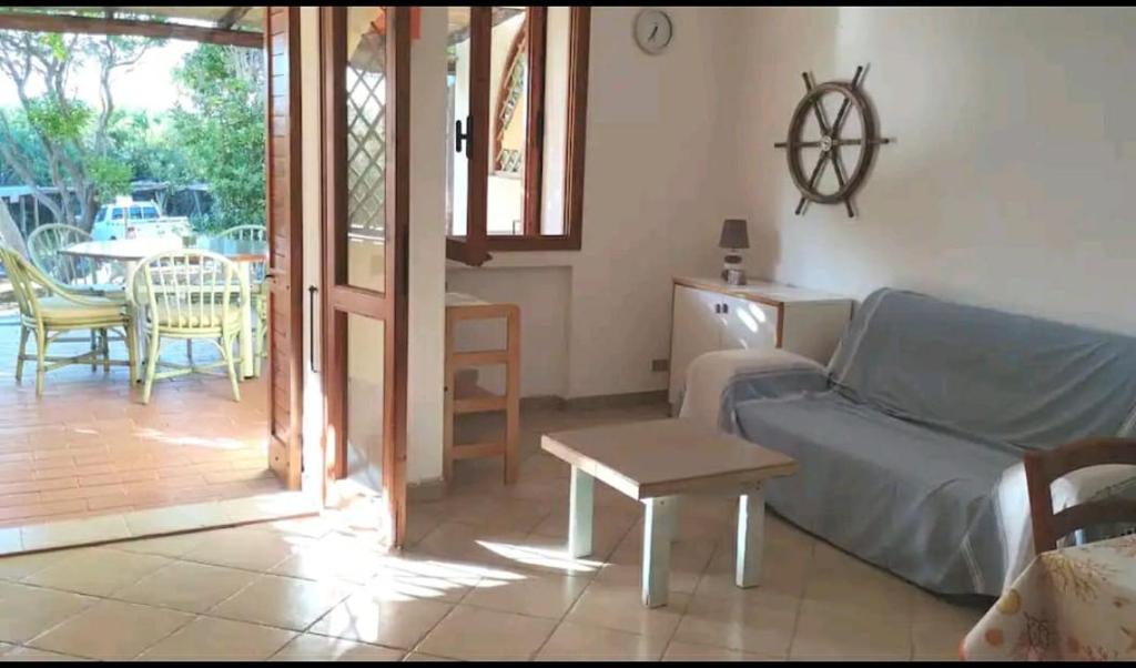 ein Wohnzimmer mit einem Sofa und einem Tisch in der Unterkunft Casa Vacanza Baja Sardinia in Baja Sardinia