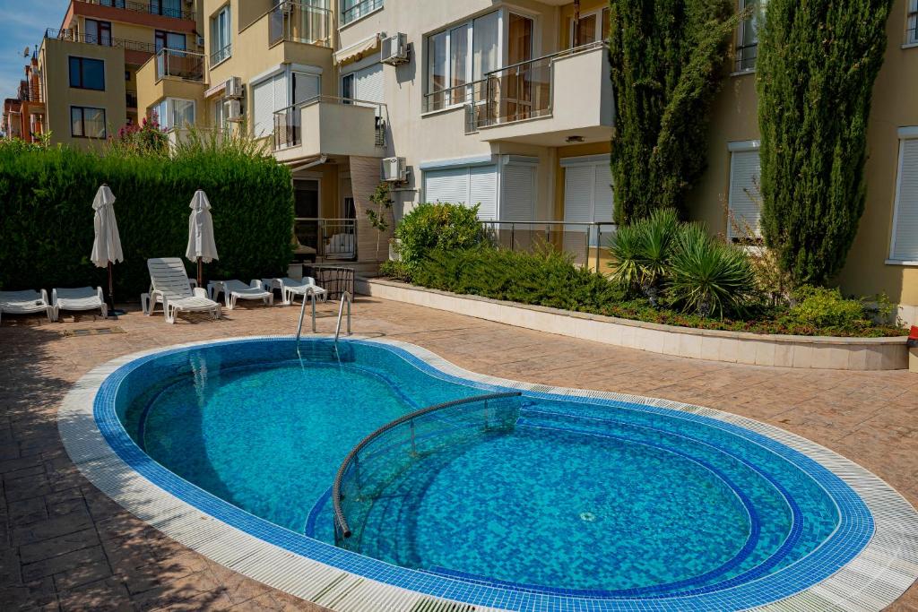 a swimming pool in front of a building at Menada Belle View Apartments in Sveti Vlas