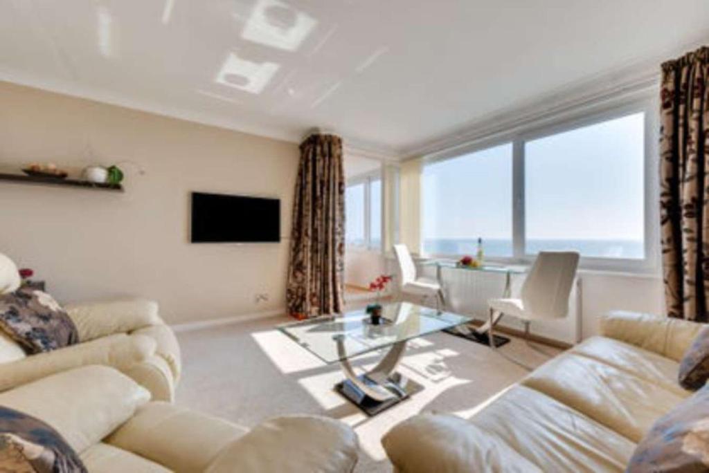 een woonkamer met een bank en een tafel bij Hove Actually with spectacular sea views in Hove