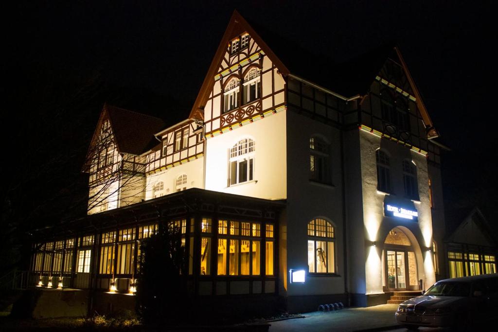 ein großes Gebäude mit Lichtern in der Nacht in der Unterkunft Hotel Müllers im Waldquartier in Bad Essen