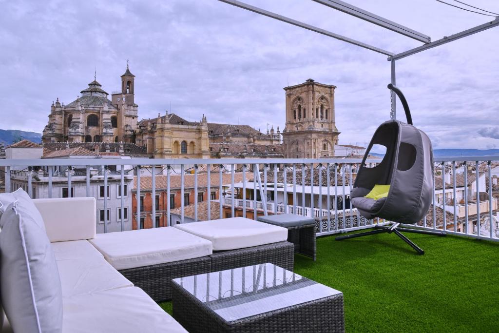 un balcón con sillas y un columpio en la azotea en Mirador de Siloé, en Granada