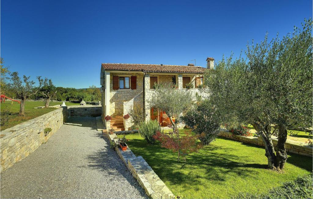 una casa con un árbol delante de ella en Beautiful Apartment In Rakalj With House A Panoramic View, en Rakalj