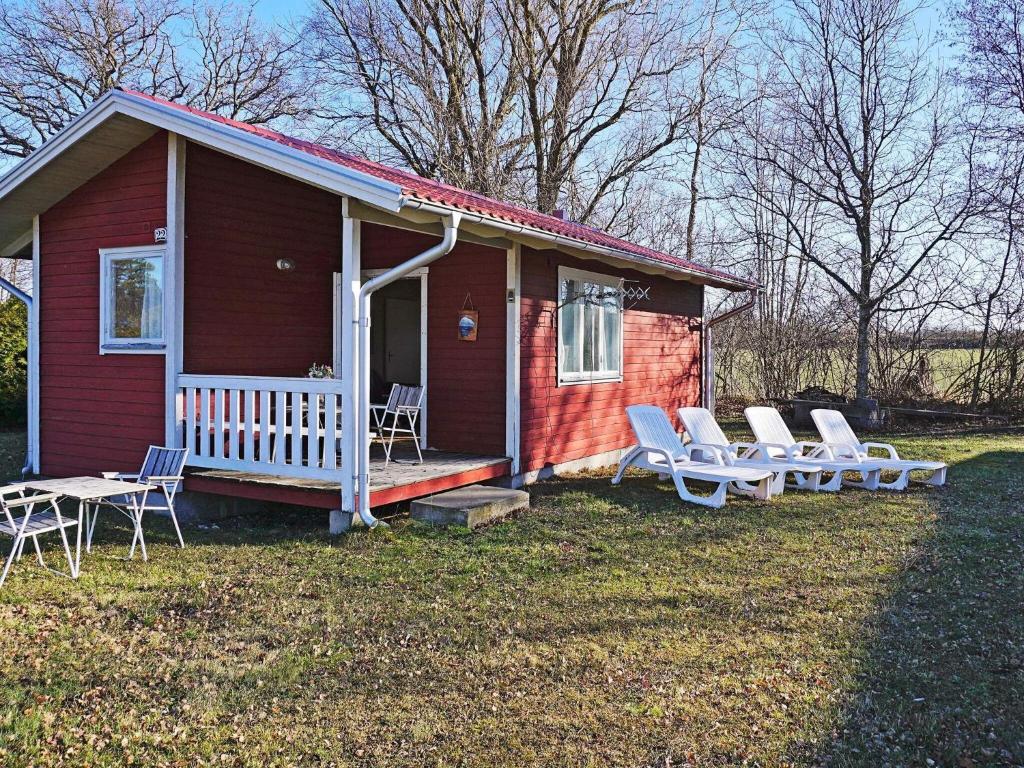 una pequeña casa roja con sillas y porche en Holiday home Mörbylånga V, en Mörbylånga