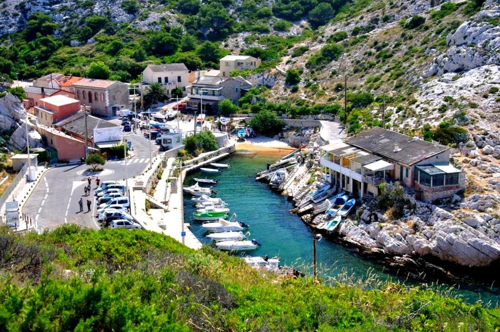 un petit port avec des bateaux dans l'eau dans l'établissement Cabanon du Pêcheur, Parc National des Calanques, à Marseille