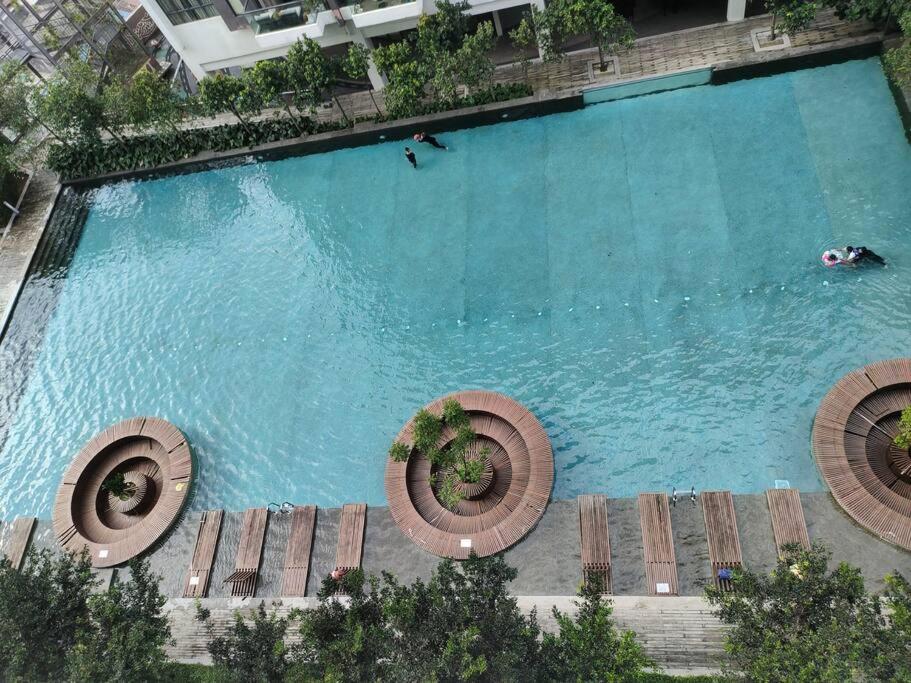 Elle offre une vue sur la grande piscine dotée de bancs en bois. dans l'établissement Urban360 Pool view stylist with android Tv, à Batu Caves