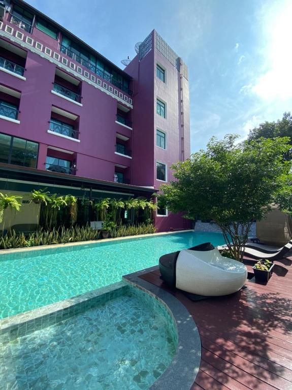 Ban Khlong Lat Bua KhaoBaan Chao Khun Hotel的一座游泳池,旁边是一座船