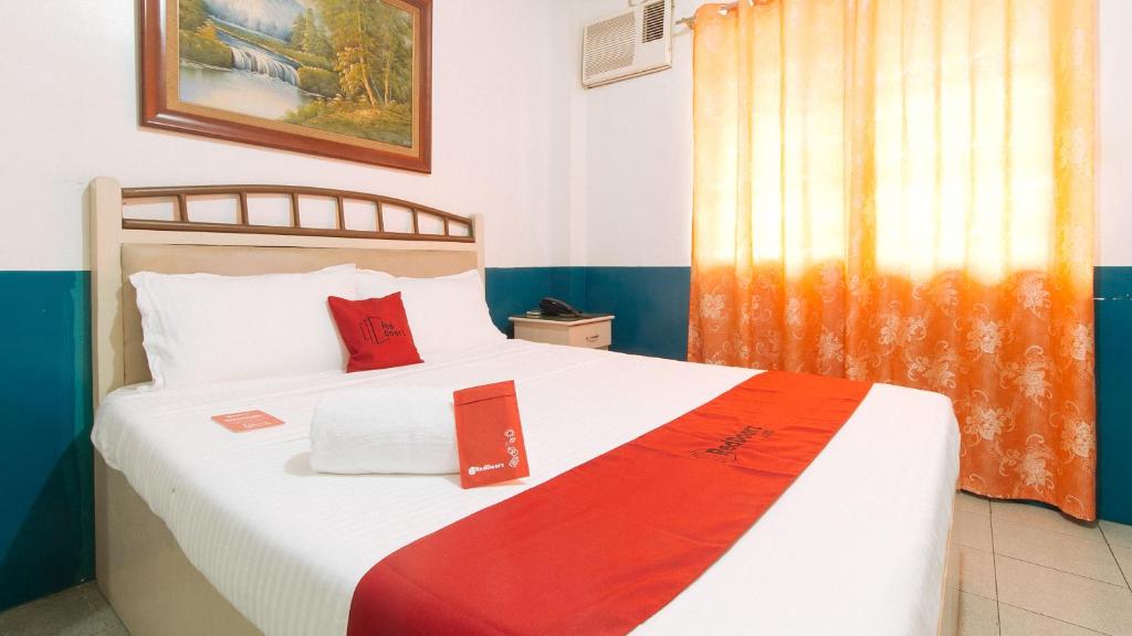 ein Schlafzimmer mit einem großen Bett mit roten Kissen in der Unterkunft RedDoorz @ Orsu Hotel Angeles Pampanga in Angeles