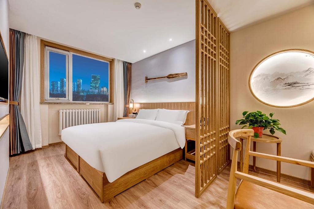 a hotel room with a bed and a mirror at Happy Dragon Universal Vacation Hotel - close to Universal Studio and Wanda Plaza,free shuttle to the Resort,Free Coffee,Laundry in Beijing
