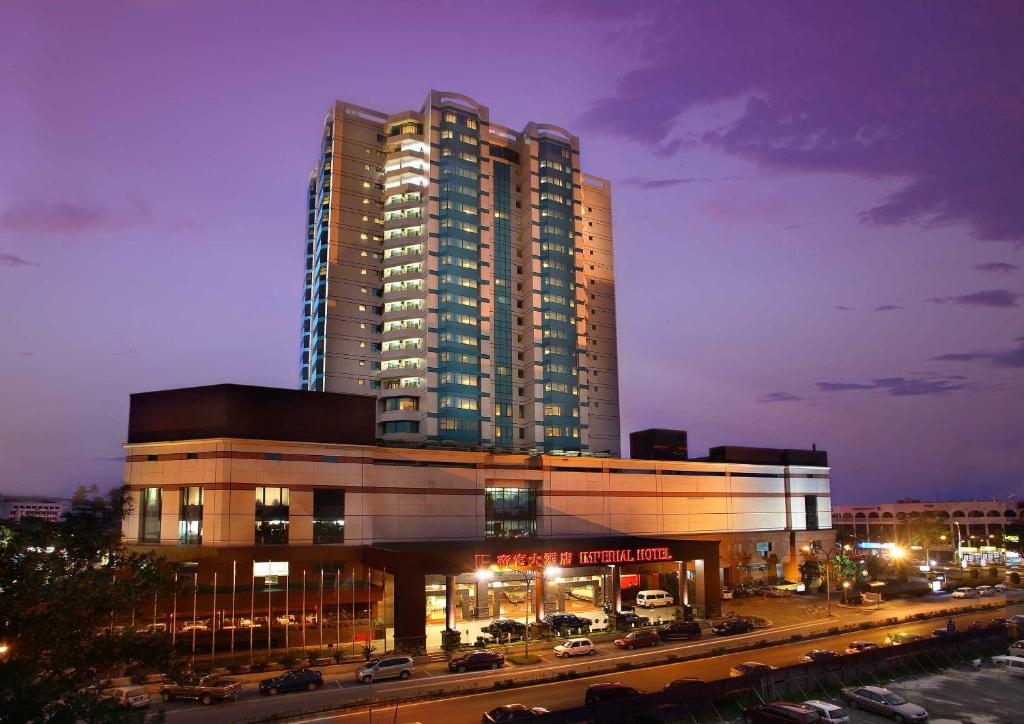 un gran edificio con coches estacionados frente a él en Imperial Hotel Miri, en Miri