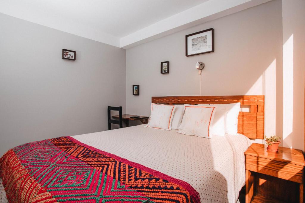 1 dormitorio con 1 cama con manta roja y blanca en Dreams House Cusco, en Cusco
