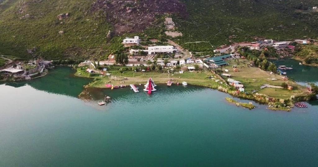 eine Insel mit einem Boot in der Mitte eines Sees in der Unterkunft Gandhara castle hotel Resort & Adventure Club in Khanpur