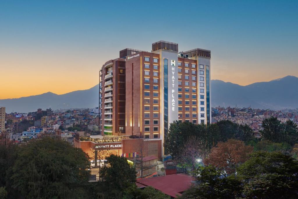 ein hohes Gebäude in einer Stadt bei Sonnenuntergang in der Unterkunft Hyatt Place Kathmandu in Kathmandu