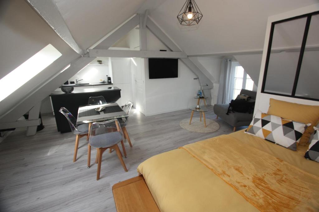 a bedroom with a bed and a table and a desk at DU SEL A LA VIE, grand studio entre marais et océan in Batz-sur-Mer