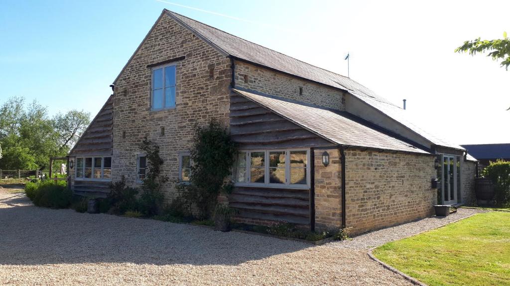 een bakstenen gebouw met een raam aan de zijkant bij The Byre North End Farm in Ashton Keynes