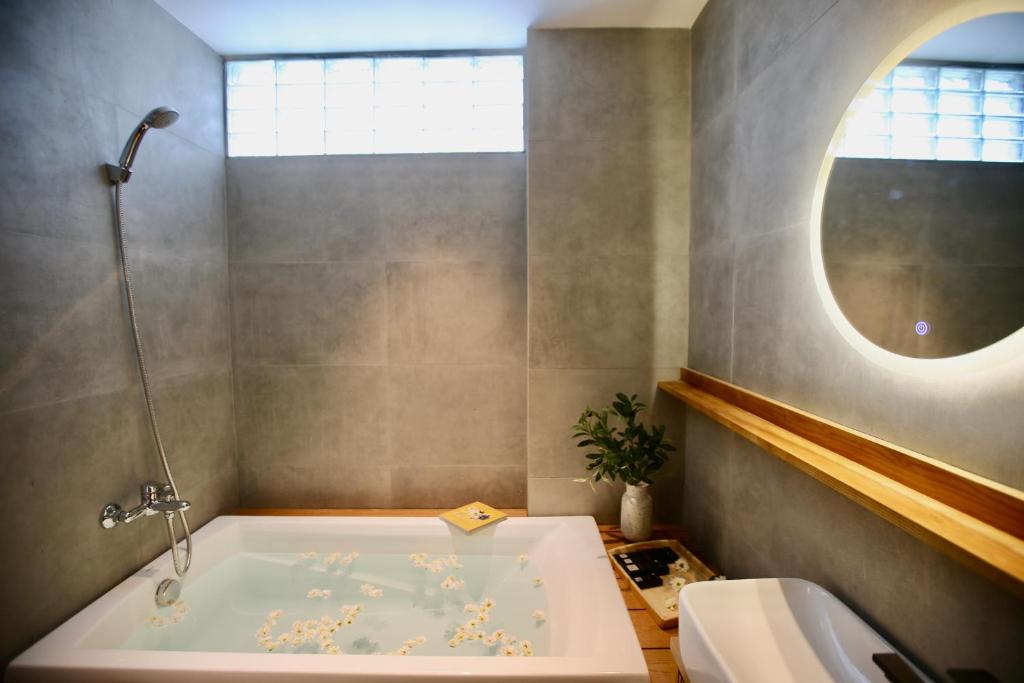 a bathroom with a bath tub and a window at Cityhouse - Ariosa in Ho Chi Minh City