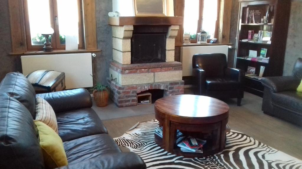 a living room with a couch and a fireplace at La Ceriseraie in La Gorgue