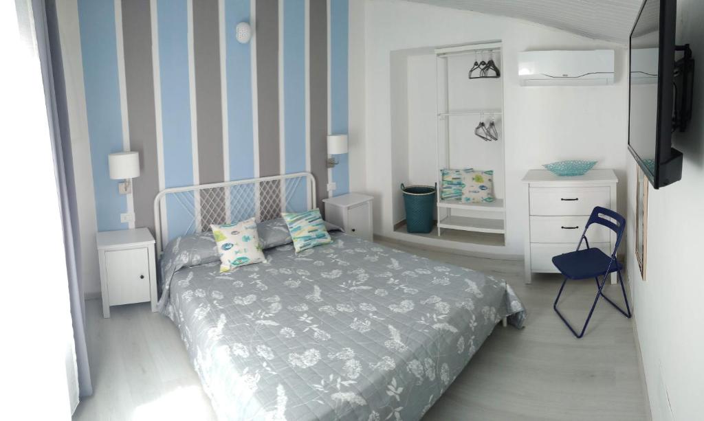 蒙泰羅索阿爾馬雷的住宿－La Casetta Rosa，一间卧室配有一张床和蓝色条纹墙