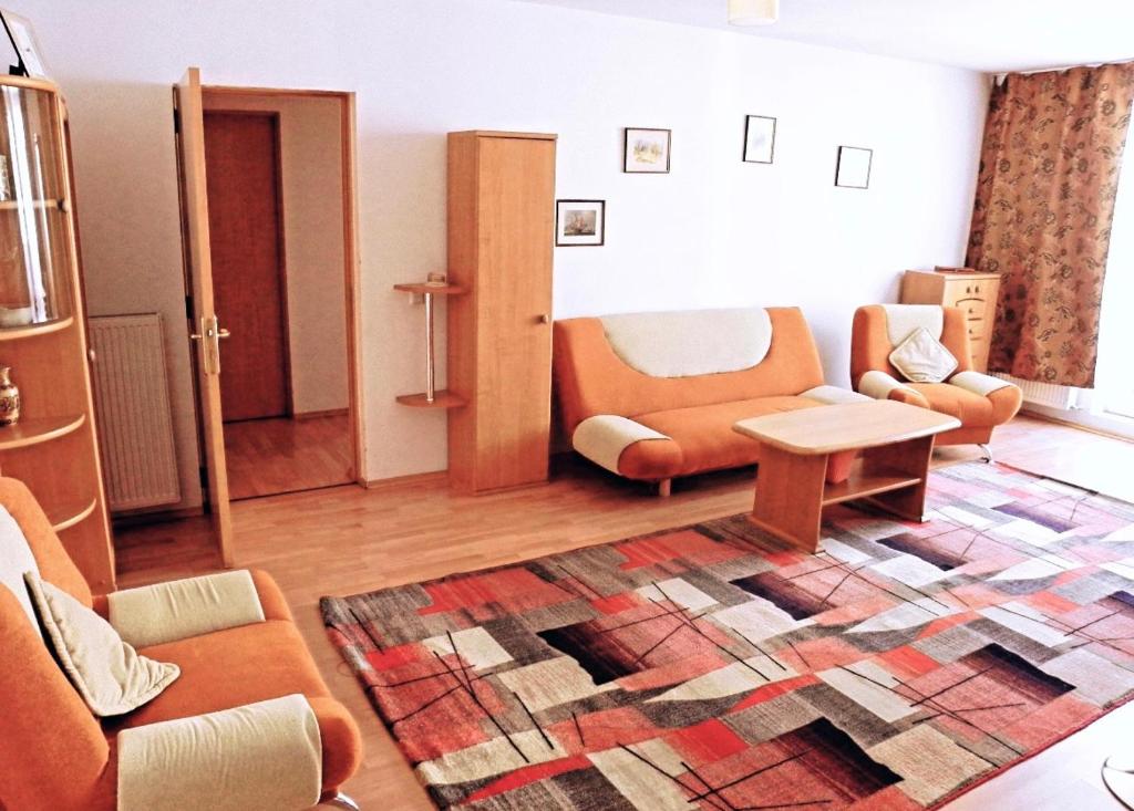 クルジュ・ナポカにあるSerenity Clujのリビングルーム(オレンジの椅子、ラグ付)