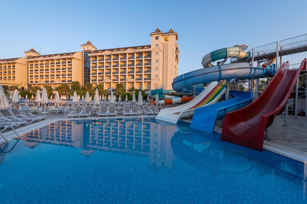 a pool with a water slide in front of a hotel at LRS Hotels Lake River Side Hotel & Spa - Ultra All Inclusive in Side