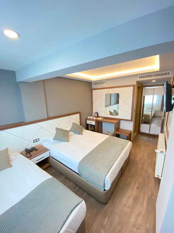 A bed or beds in a room at Hakcan Hotel