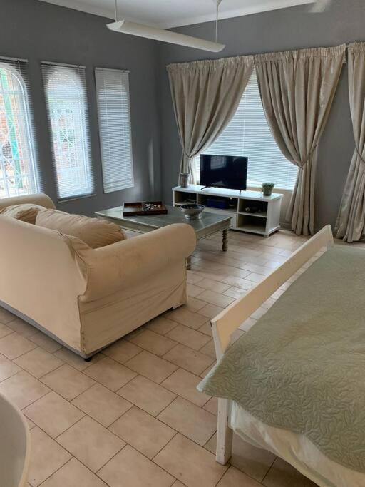 uma sala de estar com um sofá e uma televisão em 20 On Plover - Private Cottage em Sandton