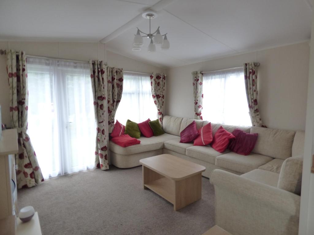 a living room with a white couch and windows at Maple Lake 170 at Southview Leisure Park in Lincolnshire