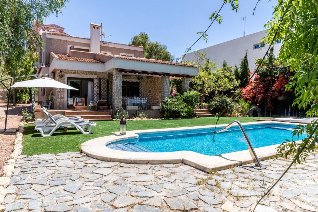 una casa con piscina nel cortile di Gran Chalet céntrico con piscina y bbq privada a 5 minutos playa ad Alicante