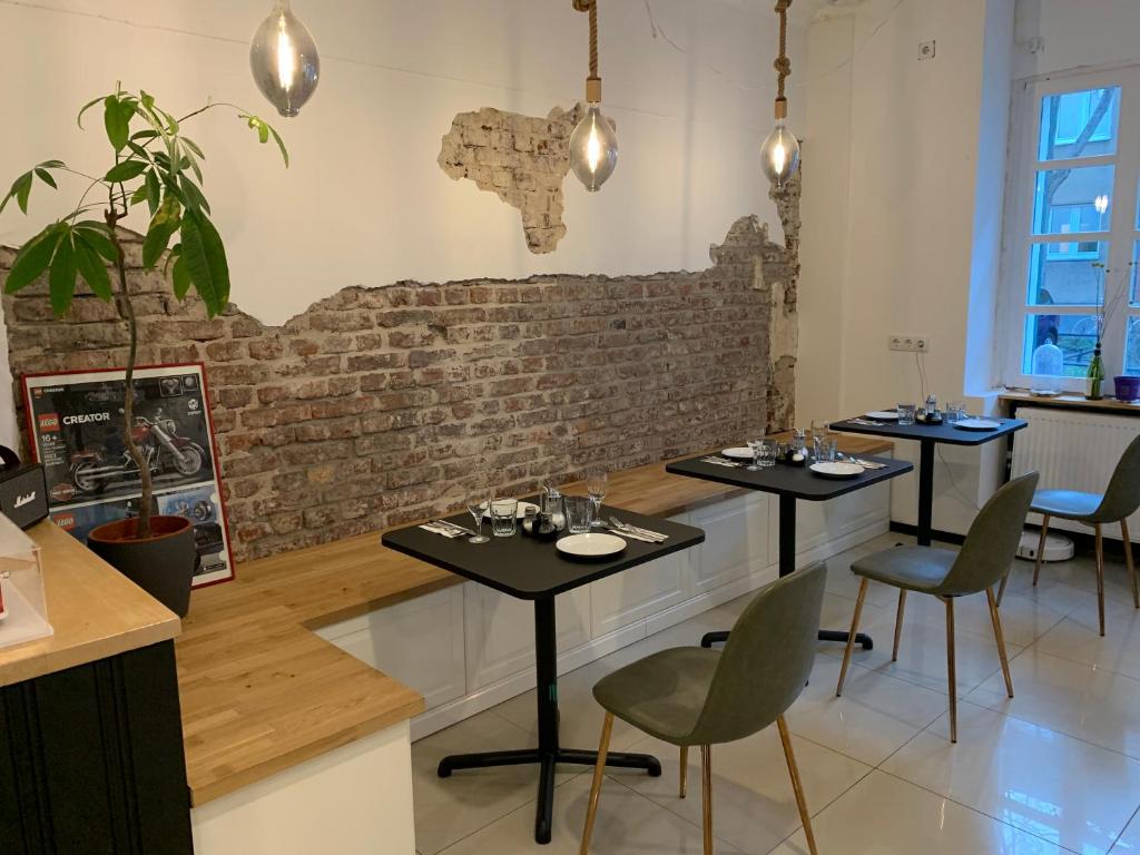 a restaurant with three tables and a brick wall at Hotel Tempelhof - City-Messe-Arena in Cologne