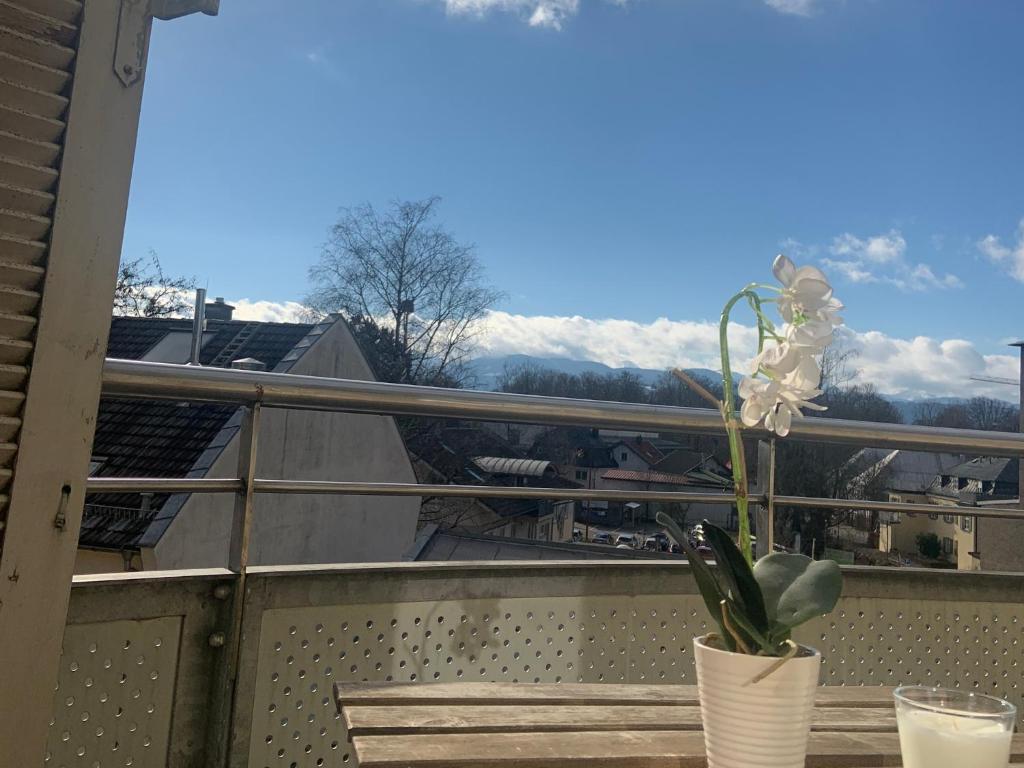 a flower in a vase on a balcony with a view at Apartment Wendelsteinblick in Bad Aibling