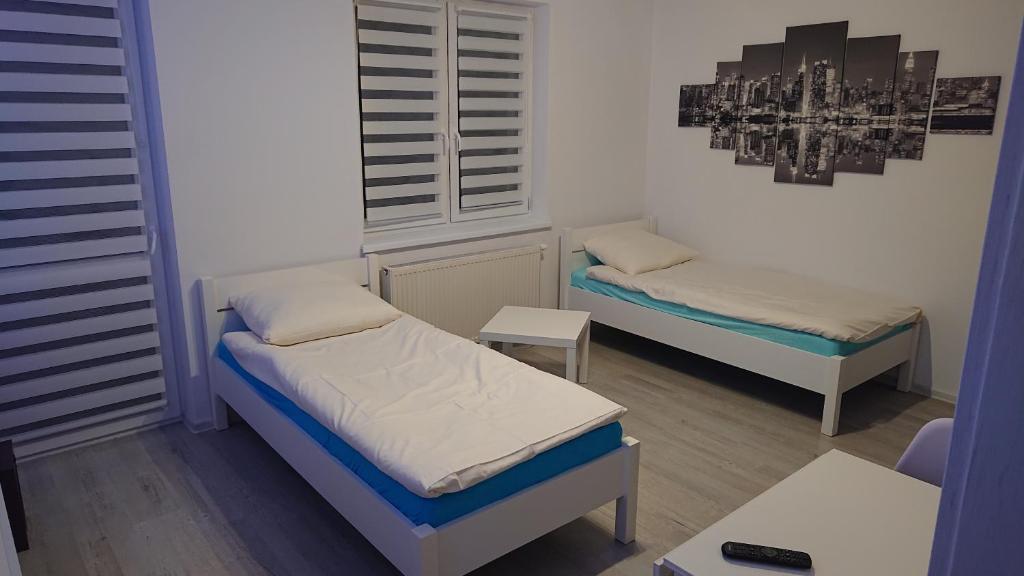 mały pokój z 2 łóżkami i stołem w obiekcie Mieszkanie dla pracowników darmowy parking w Słubicach