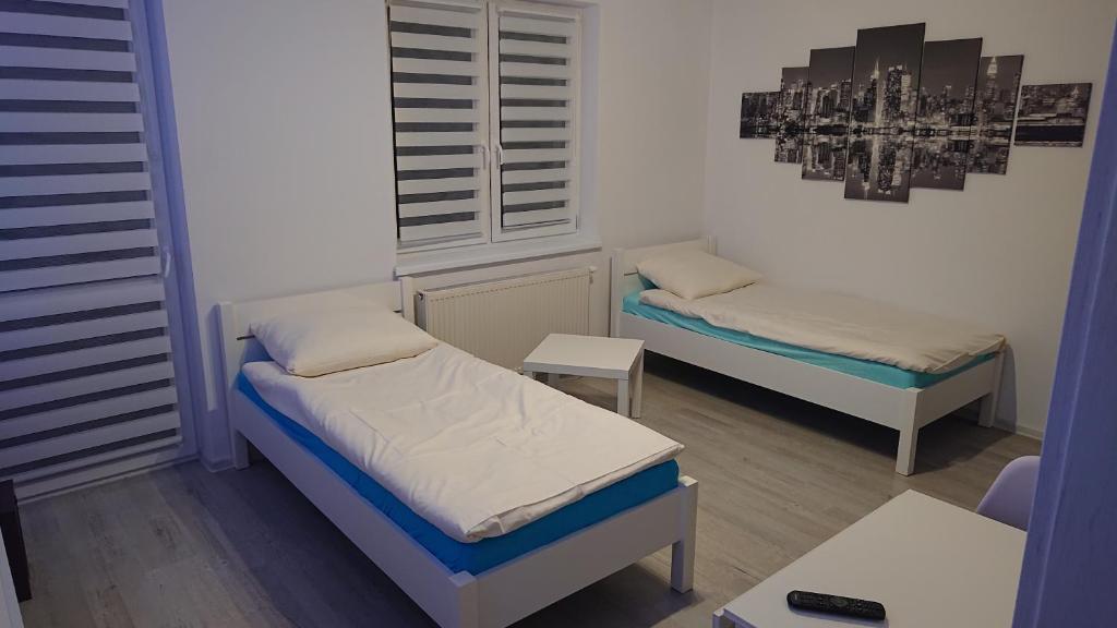 a small room with two beds and a table at Mieszkanie dla pracowników darmowy parking in Słubice
